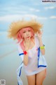 A woman in a straw hat on the beach.