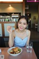 A woman sitting at a table with a plate of food.