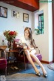 A woman sitting on a chair reading a book.