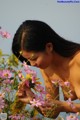 A naked woman in a field of pink flowers.