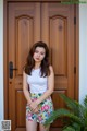 A woman standing in front of a wooden door.