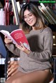 A woman sitting on a chair reading a book.